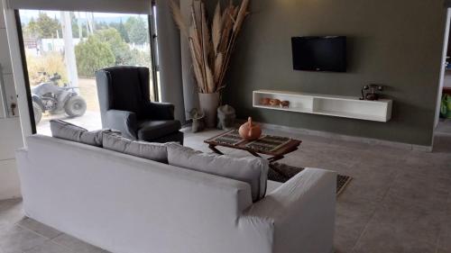 ein Wohnzimmer mit einem weißen Sofa und einem Sessel in der Unterkunft Villa Guillermina in Villa Giardino