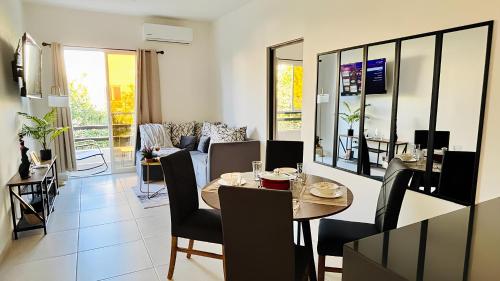 a dining room and living room with a table and chairs at Amplio departamento 3 recámaras con pool ideal familias y grupos AC WiFi in Playa del Carmen