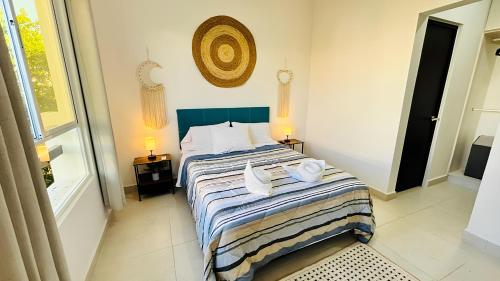 a bedroom with a bed with two towels on it at Departamento moderno con alberca ideal para una escapada cómoda in Playa del Carmen