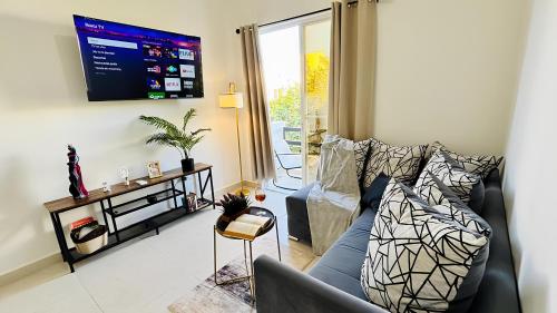 a living room with a couch and a tv at Departamento moderno con alberca ideal para una escapada cómoda in Playa del Carmen