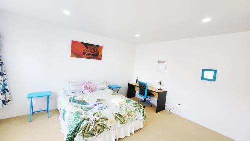 a white room with a bed and a desk and a bed at Private guest suite near the airport 1-4 guests in Auckland