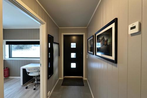 een gang met een zwarte deur en een tafel en een stoel bij Premium Rural Apartment - Leknes in Leknes