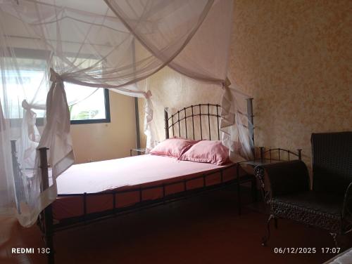 een slaapkamer met een hemelbed en een raam bij Appartement Saly plage in Saly Portudal