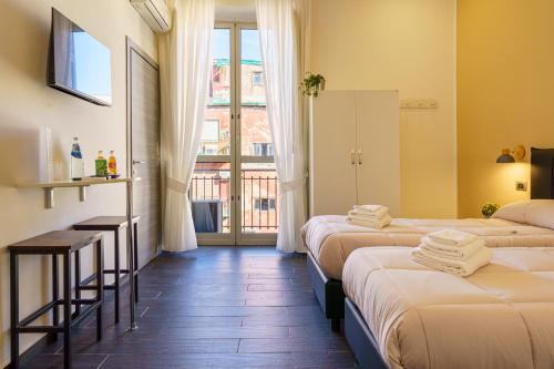 a hotel room with three beds and a window at Calaba SpaccaNapoli in Naples