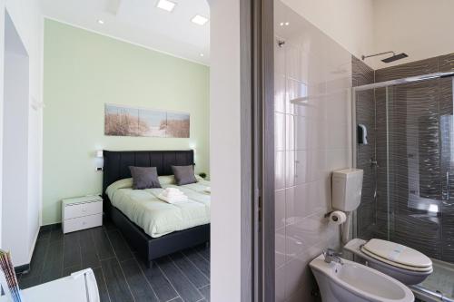 a bedroom with a bed and a bathroom with a shower at Calaba SpaccaNapoli in Naples