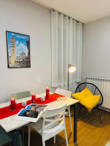 a dining room with a table and chairs with a red blanket at AB apartment Pistoia in Pistoia