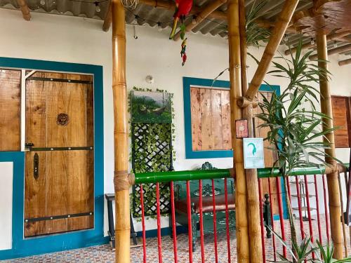 a room with wooden pillars and a green railing at Casa Santa Rosa Garden in Santa Rosa de Cabal