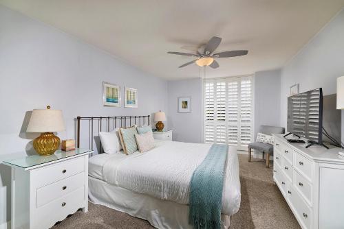 una camera da letto bianca con un letto e un ventilatore a soffitto di F204 - Cozy Seaview Condo a Oceanside