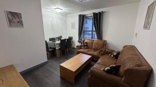 a living room with a couch and a coffee table at Chic Above Store in Tredegar
