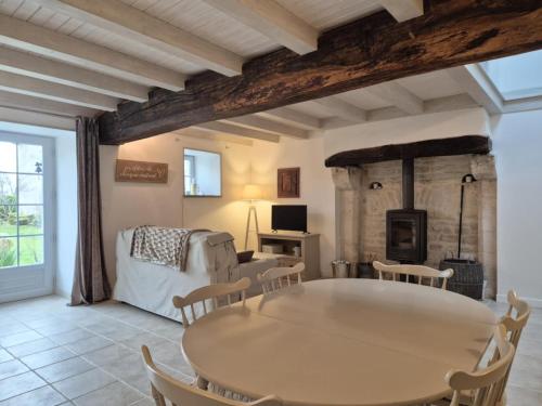 un salon avec une table et des chaises et une cheminée dans l'établissement La Charmésienne, à Charmé