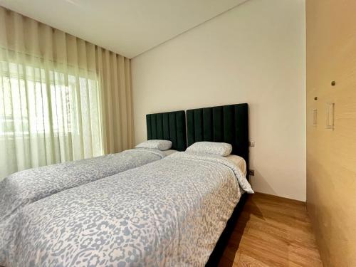 Urban Chic 2BR - Prestigia near stadium في الرباط: سريرين يجلسون بجانب بعض في غرفة النوم