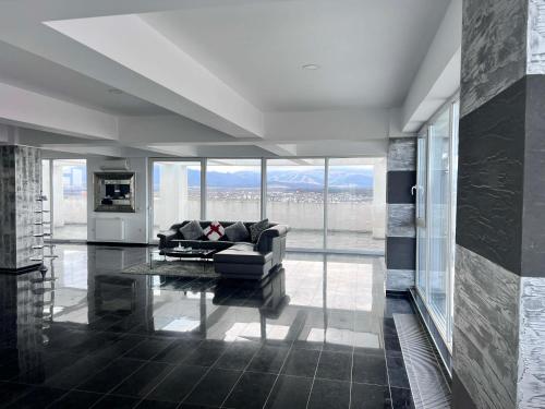 a living room with a couch and a large window at Sky17 Penthouse Sibiu in Şelimbăr