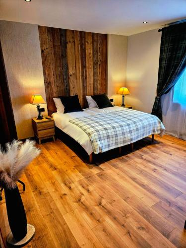 a bedroom with a bed and two lamps on two tables at Chalet Du Centre in Aosta