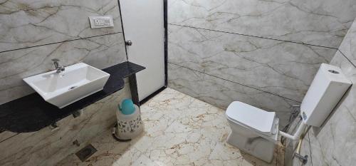 a bathroom with a sink and a toilet at HOTEL MAHER Inn in Ahmedabad