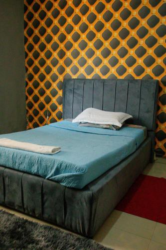 niebieskie łóżko w pokoju ze ścianą w obiekcie Collins apartment w Ndola