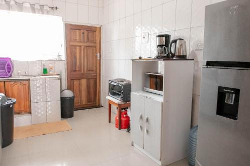 kuchnia z lodówką i kuchenką mikrofalową w obiekcie Collins apartment w Ndola