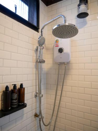 a shower with a shower head in a bathroom at Baan Ati Villas in Ban Han Pa To