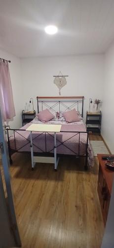 a bedroom with a bed with purple sheets and pink pillows at Casa da Aldeia in Figueiró dos Vinhos