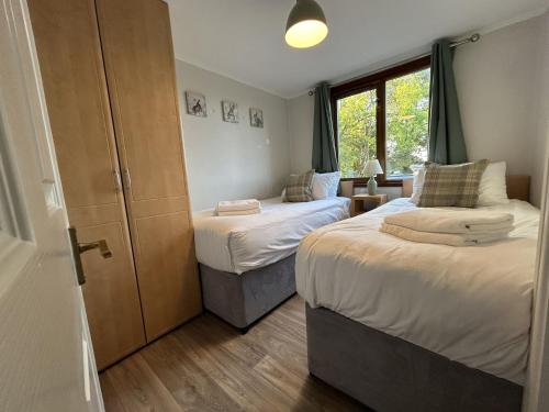 ein Schlafzimmer mit zwei Betten und einem Fenster in der Unterkunft Athelington Lodge - Oak in Horham