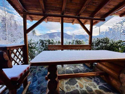 Un porche con una mesa y vistas a las montañas. en Iepurasul Sinaia, en Sinaia