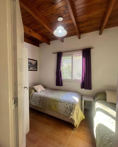 a bedroom with two beds and a window at Cabaña Paz in Capilla del Monte