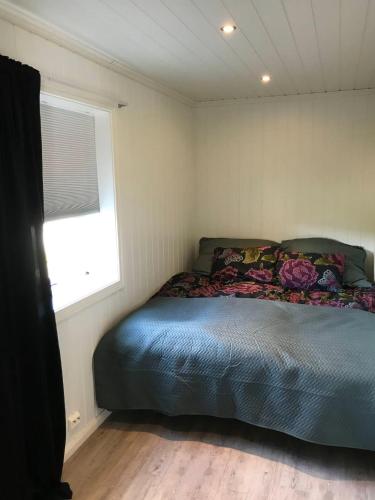 a bed in a small room with a window at Hamsun Panorama med sauna in Åmli