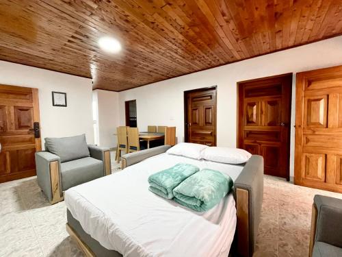 Un dormitorio con una cama con dos sillas y una mesa. en Navidad en familia 2 hab balcón cerca CC Mayorca, en Sabaneta