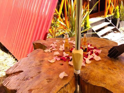 a table with two bottles of beer and flowers on it at Cabaña El Resguardo in La Capilla
