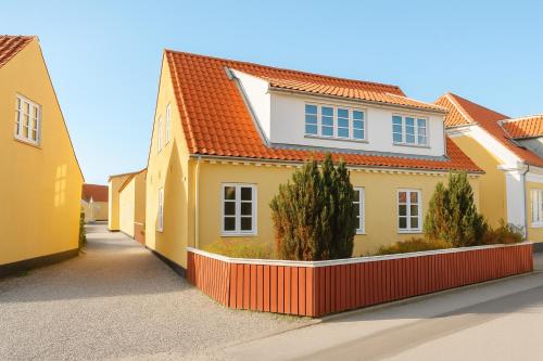 a house with a red fence in front of it at GBH - Central Townhouse in Skagen in Skagen