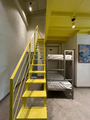 a yellow staircase in a room with bunk beds at Testudo Madiha in Matara