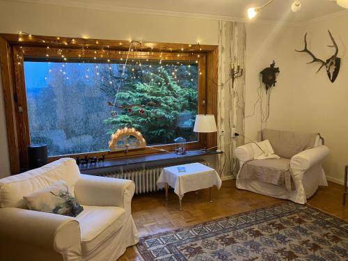 a living room with two white couches and a large window at Ferienhaus-stadtkyll-eifel Beim Förster mit zwei Schlafzimmern in Stadtkyll