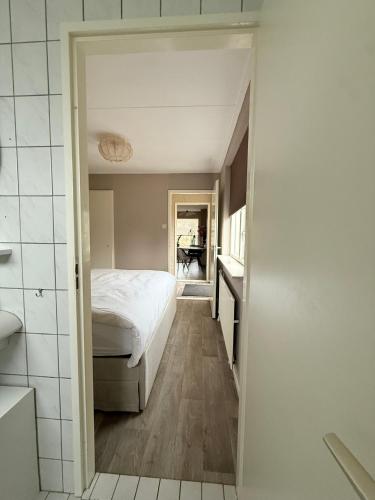un dormitorio con una cama y un baño en Bed & Bloom, en Barneveld