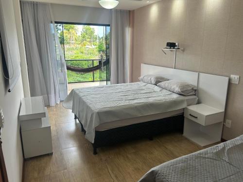 Casa em condomínio Guarapari ES في غواراباري: غرفة نوم بها سرير ونافذة كبيرة