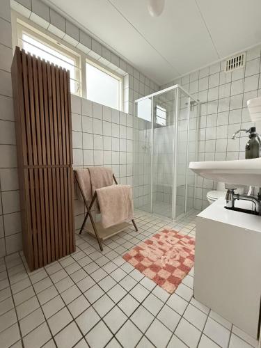 un baño con ducha y lavabo en Bed & Bloom, en Barneveld