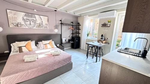 a bedroom with a large pink bed and a table at ES Apartments in Nago-Torbole