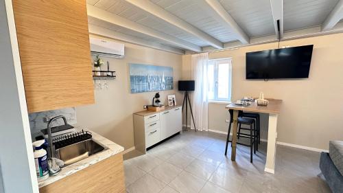 een kleine keuken met een tafel en een televisie bij ES Apartments in Nago-Torbole