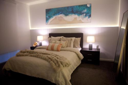 een slaapkamer met een groot bed met 2 lampen erop bij Entire home in Cranbourne West in Cranbourne