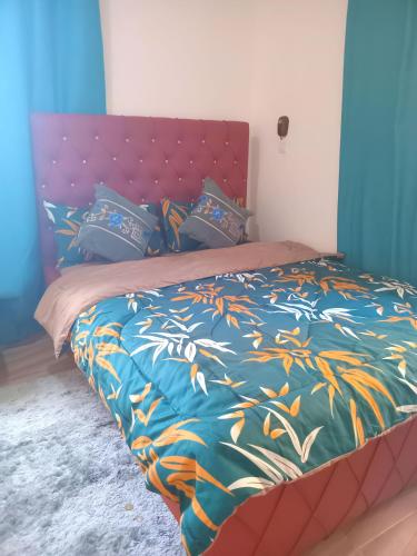 Una cama con un edredón y almohadas de colores en Master Home, en Baatsona