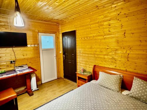 een slaapkamer met een bed en een televisie en een deur bij Casa Beijing in Braşov