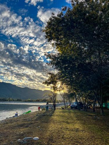 a group of people standing on a beach near a body of water at NaboCamp in Linares