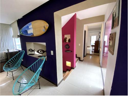 a hallway with two chairs and a wall with a surfboard at Ostende frente al mar in Ostende