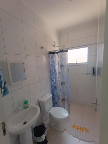 a bathroom with a toilet and a sink and a shower at Aconchego em Bertioga in Bertioga