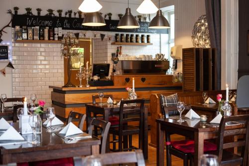 a restaurant with wooden tables and chairs and a counter at The Courie Inn in Killin