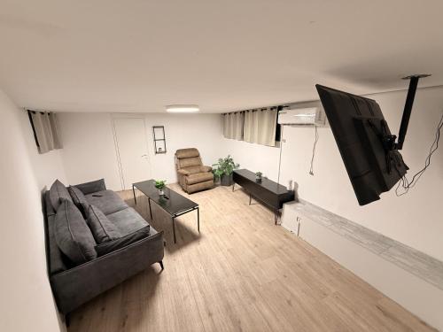 uma sala de estar com um sofá e cadeiras e uma televisão de ecrã plano em SeaSide Villa em Asdode