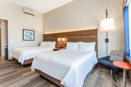 Una habitación de hotel con dos camas y una silla. en Holiday Inn Express & Suites - Springfield North by IHG, en Springfield