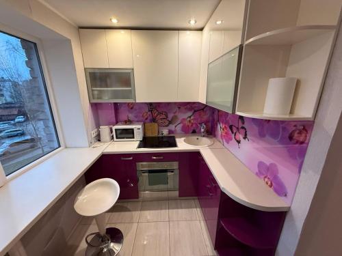 eine Küche mit lila und weißen Schränken und einer Spüle in der Unterkunft Armin Castle to Stay in Jelgava