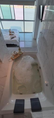 a large bath tub in a bathroom with a window at Ecusuites Skyline Jacuzzi Premium Riverfront 12 in Guayaquil