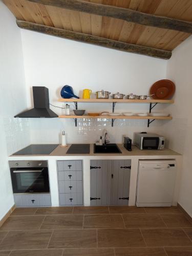 a kitchen with white cabinets and a sink in it at Casas da Lola - Mourão in Mourão