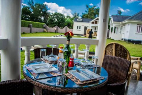 a table with plates and glasses on a porch at Fortbella Tourist Inn in Njara