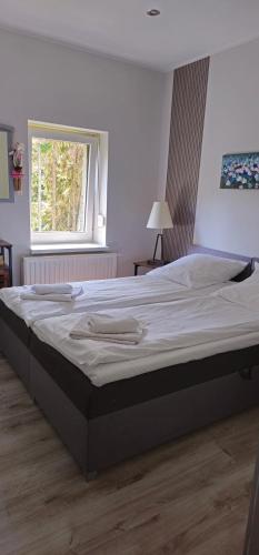 a large bed in a bedroom with a window at Szafirowy Zakątek in Karpacz